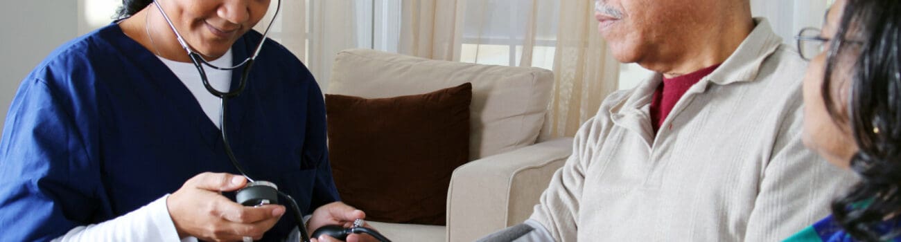 Healthcare assistant checking blood pressure Healthcare assistant checking blood pressure